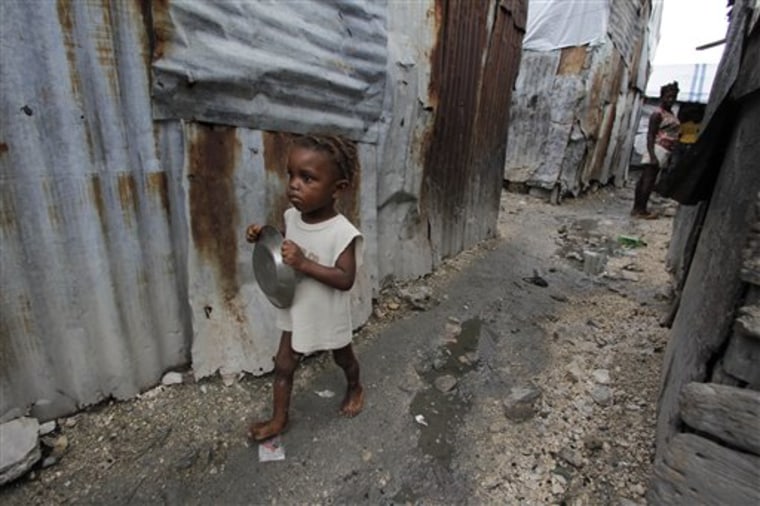 A girl carries a shared steel food plate after eating a portion of oily rice for breakfast, in Port-au-Prince, Haiti. Health workers believe there are thousands of malnourished children, mostly in hard-to-reach rural areas, slowly suffering out of sight of the massive humanitarian effort in the capital.